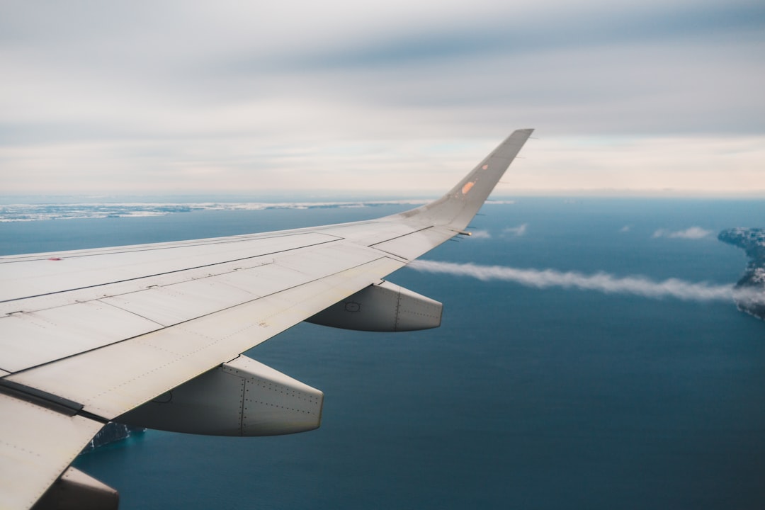 white airplane wing over blue sky during daytime