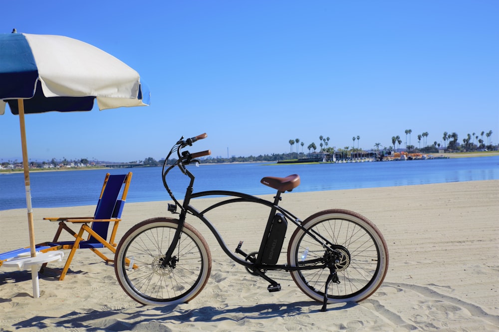 Bicicleta negra en la playa durante el día