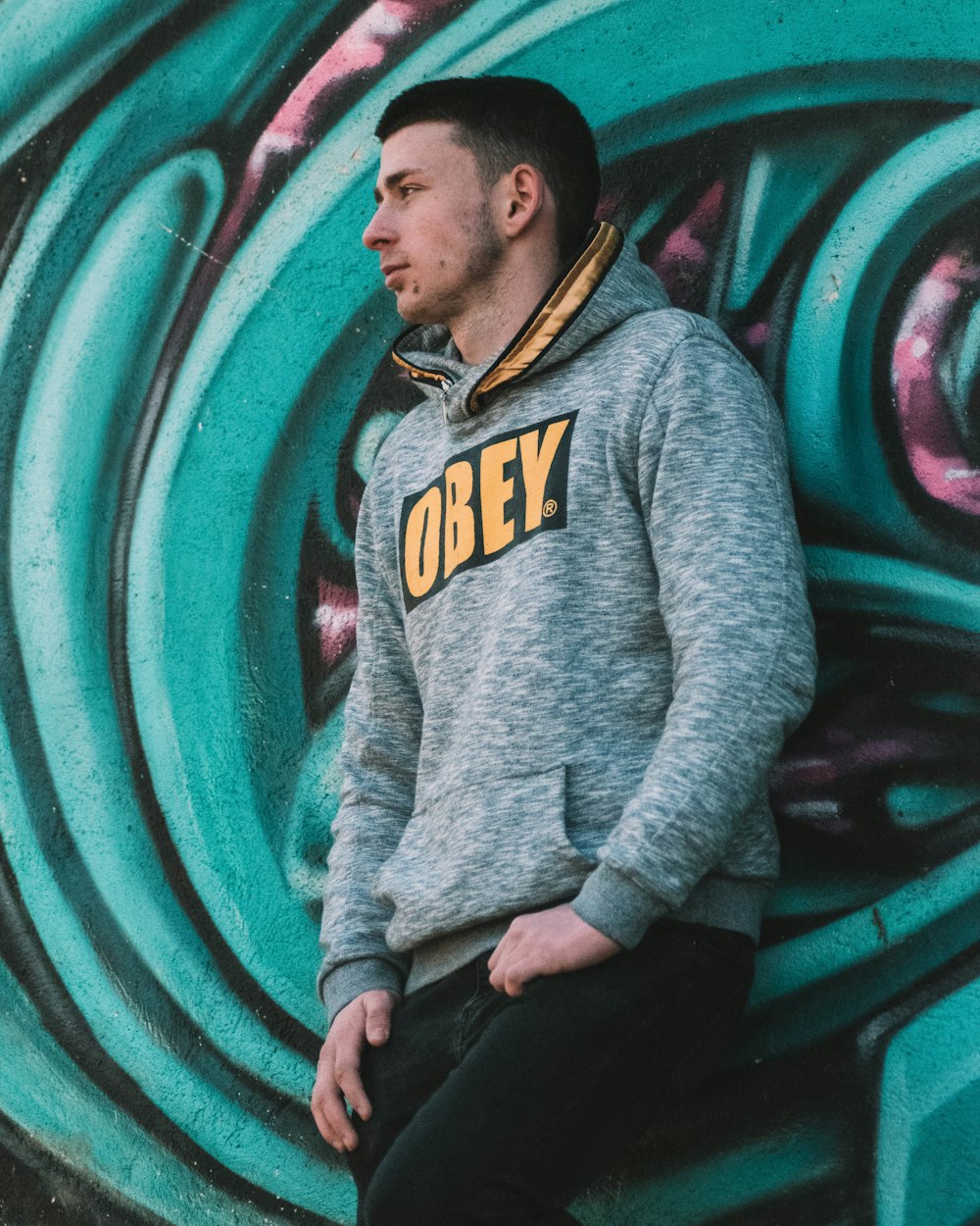 man in gray hoodie sitting on green and black tunnel