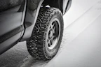 Winter tires with deep treads covered lightly with snow