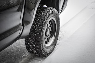 A rugged tire gripping a wet road surface during a rainy drive.