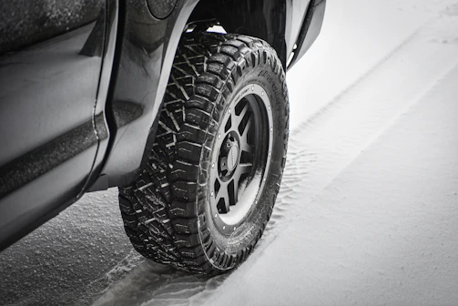 Winter tires with deep treads covered in fresh snow