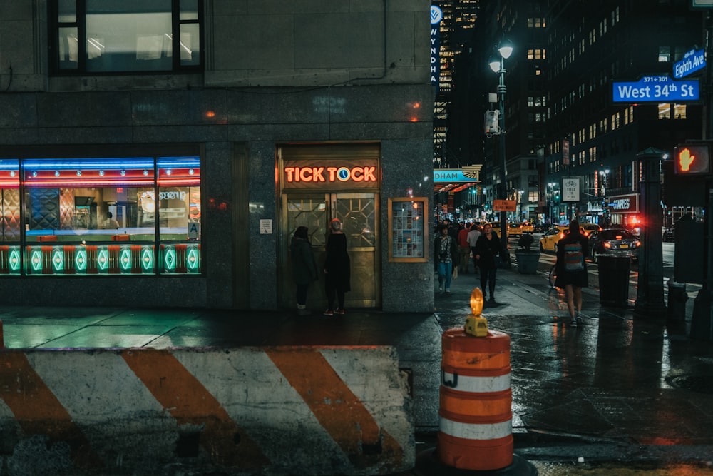 people walking on sidewalk during night time