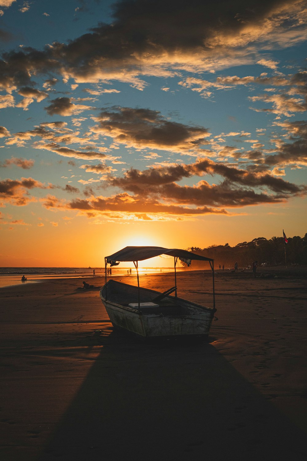 blue boat on beach during sunset