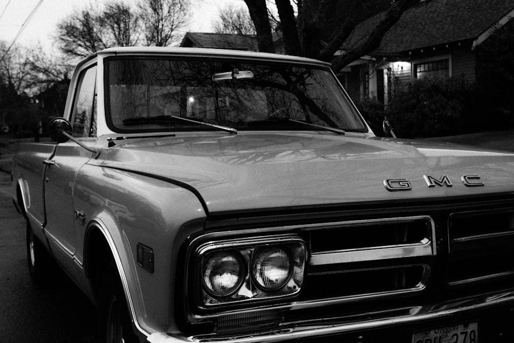 grayscale photo of car in front of building