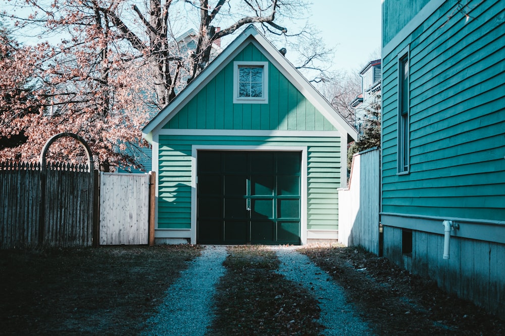 Maison en bois bleu et blanc près des arbres bruns pendant la journée