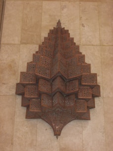 Close-up of an intricately laser-cut wooden wall art piece with delicate patterns.