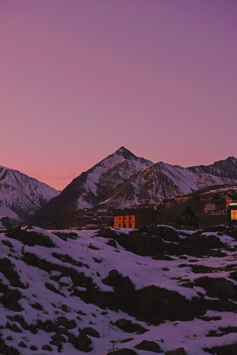 brown and gray house on snow covered ground near mountain during daytime