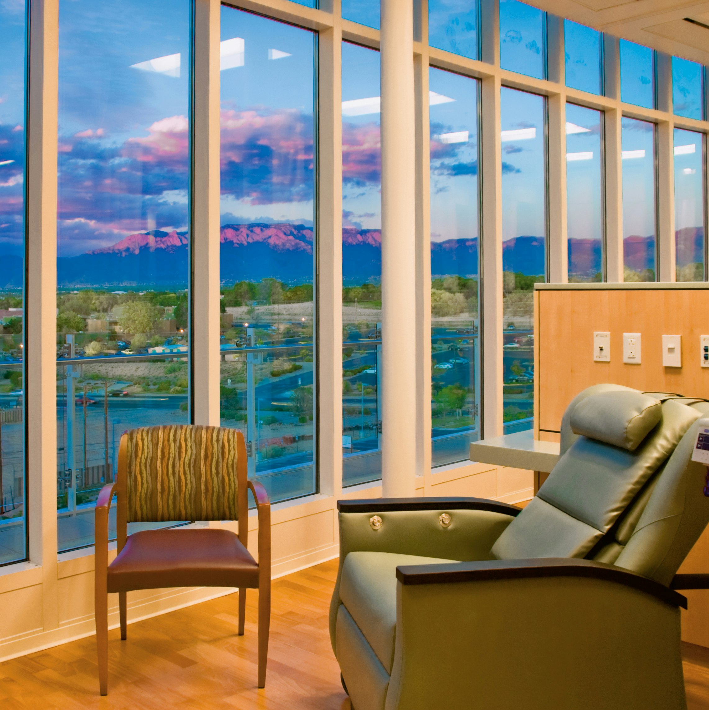The chemotherapy infusion suite with a view of the Sandia Mountains at the University of New Mexico Cancer Center (UNMCC) in Albuquerque. Since first achieving National Cancer Institute designation in 2005, UNMCC and its consortium institutions -- Lovelace Respiratory Research Institute, Los Alamos National Laboratory, and Sandia National Laboratories -- have built a single transdisciplinary cancer-focused research enterprise and statewide networks for cancer care delivery and community participatory research.