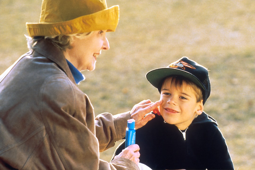 boy in black hat holding blue plastic bottle