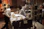 A medical setting with two people, likely healthcare professionals, focusing on a patient who is surrounded by numerous medical devices and monitors. The environment is busy with various tubes and equipment connected to the patient.