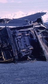 wrecked black car on gray sand during daytime