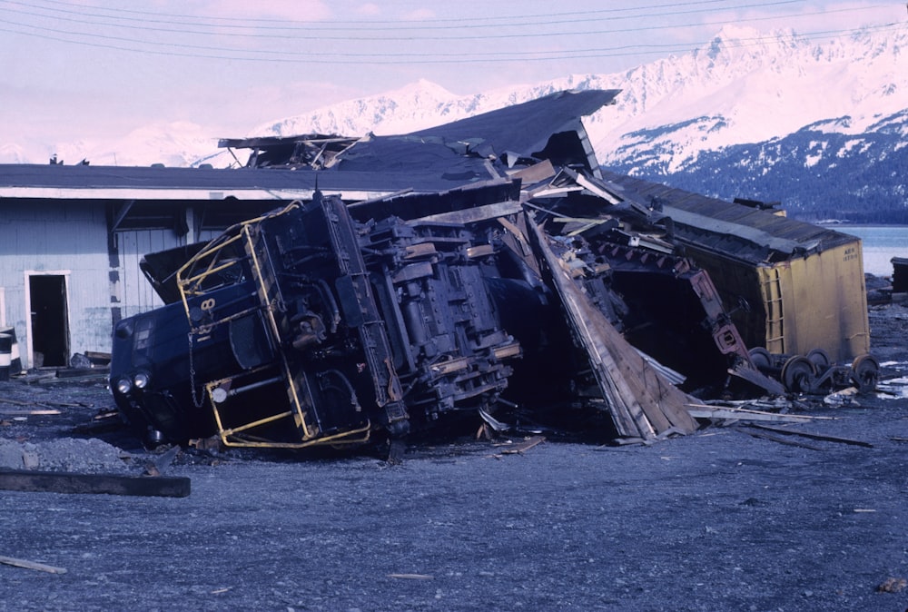 wrecked black car on gray sand during daytime