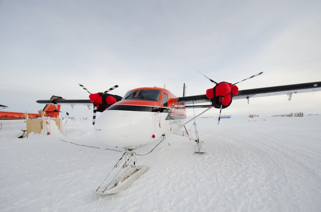 red and white helicopter on snow covered ground