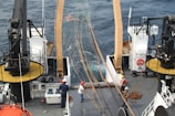Modern fishing boat at sea with crew handling sustainable catch.