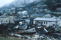 white and brown boat on black sand during daytime