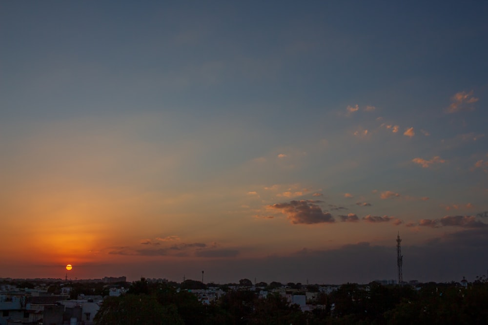 city with high rise buildings under orange and blue sky