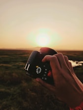 Tarun Singh thoughtfully adjusting his camera settings outdoors during a golden hour shoot.