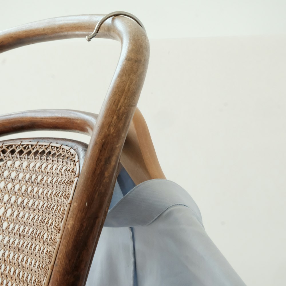 person in gray pants sitting on brown woven chair