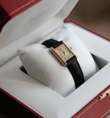 gold and black analog watch in box