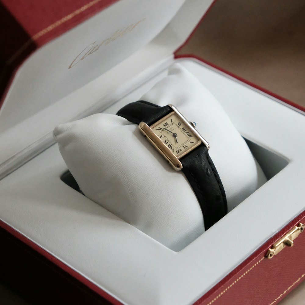 gold and black analog watch in box