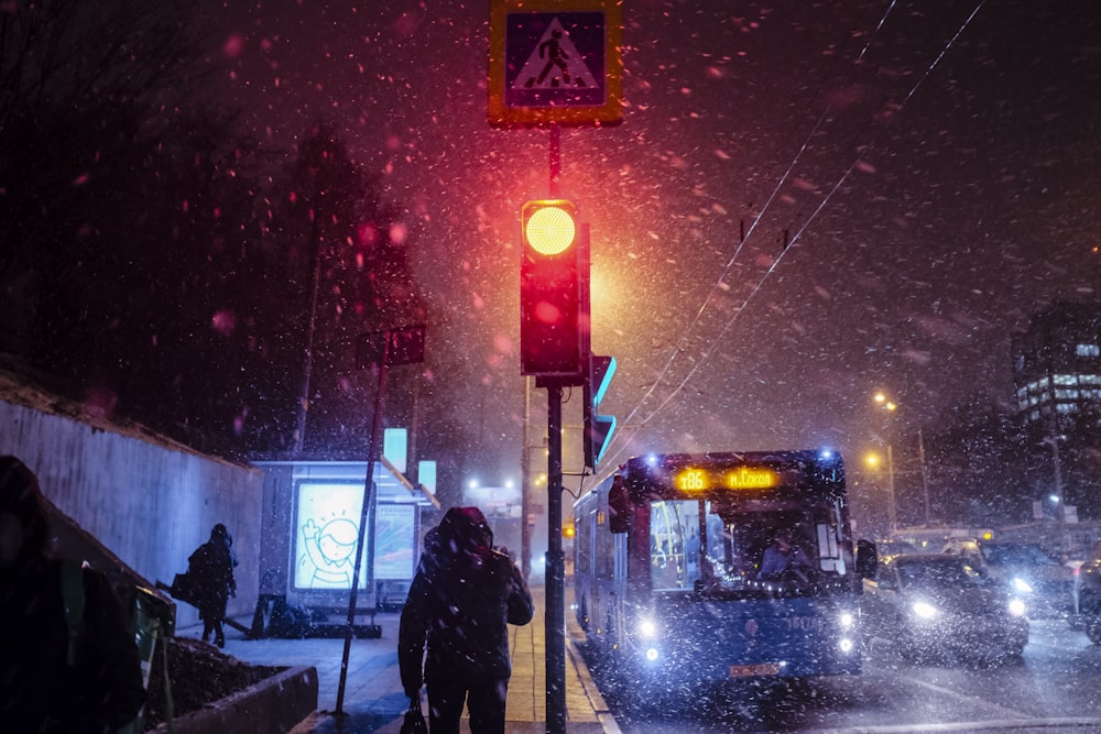 silhouette of person standing near traffic light during night time