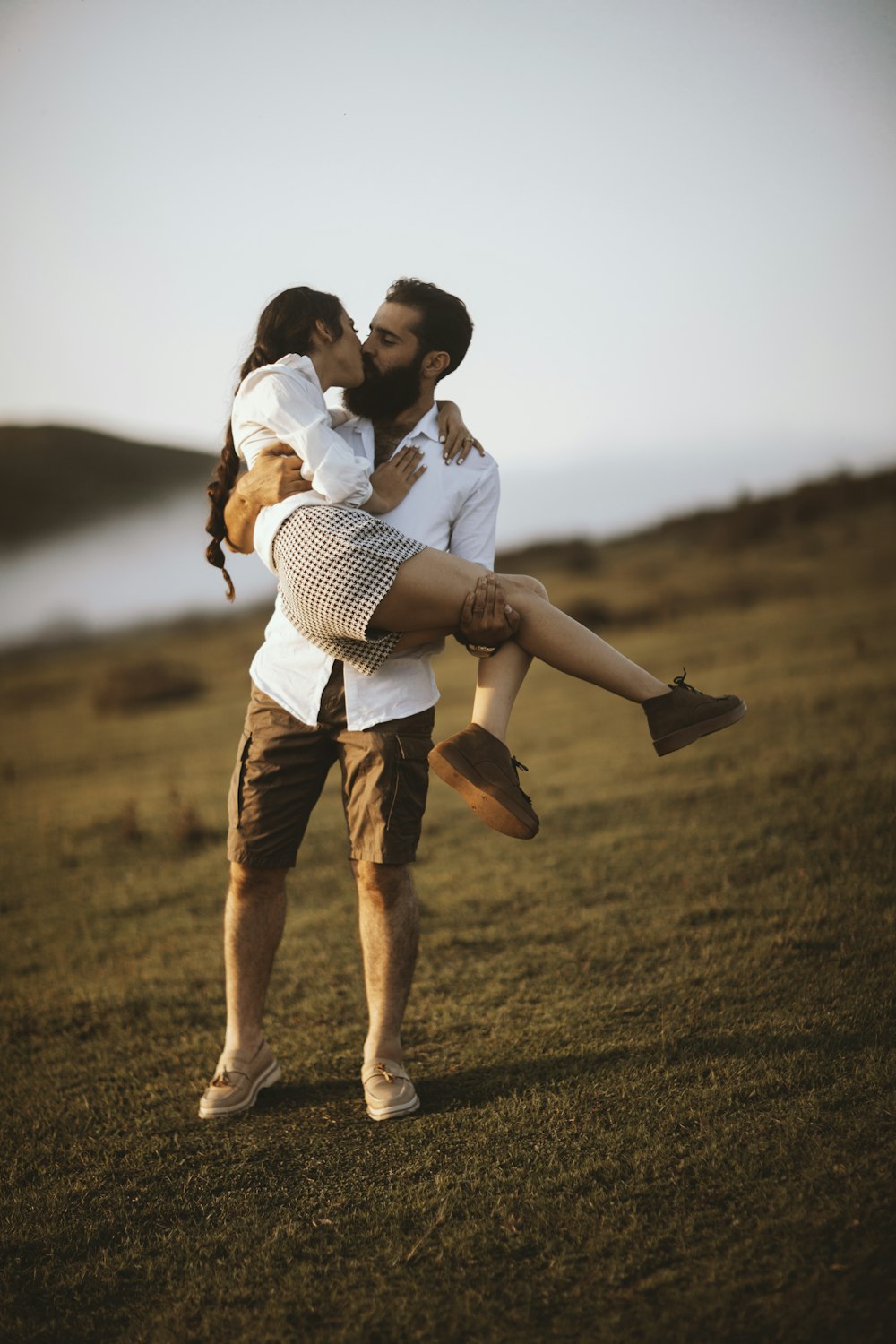 man in white and black striped shirt carrying woman in white and black striped shirt