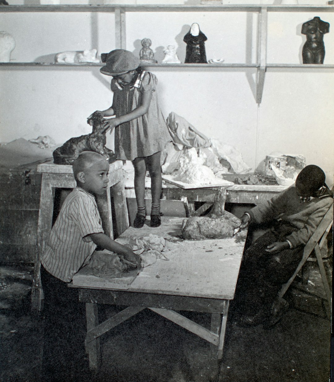 Young children in sculpture studio working with clay