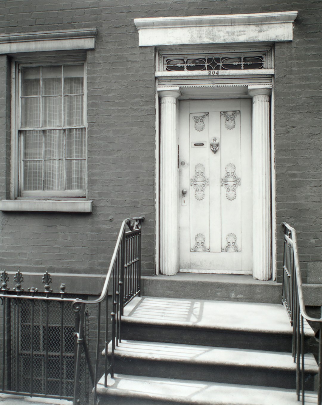 white wooden door beside black steel fence