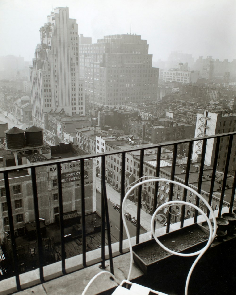 Pequeño balcón con silla blanca cerca de los edificios de la ciudad durante el día