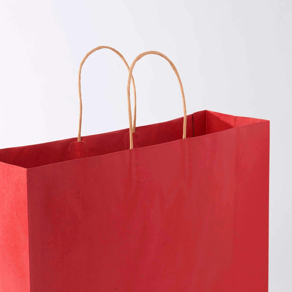 A red paper bag with brown handles.