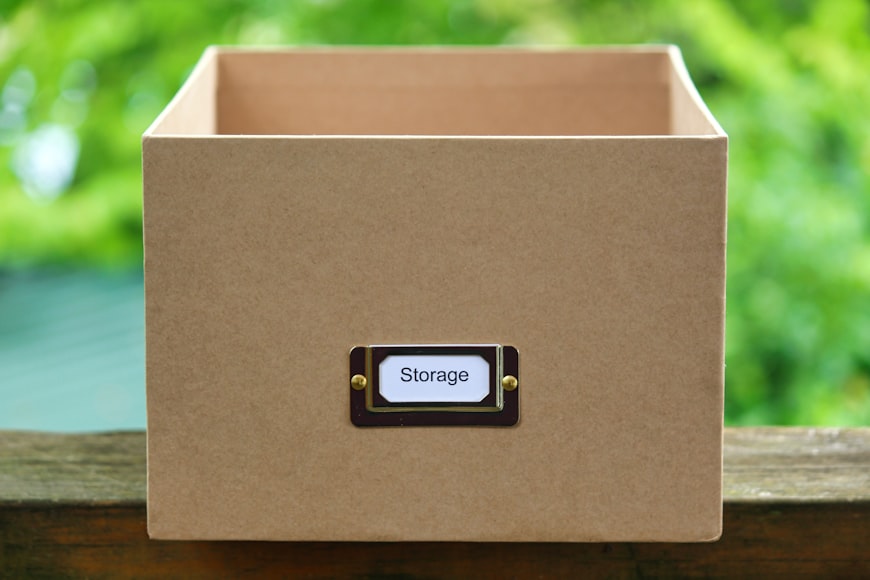 Kartonowe pudło z napisem „Storage” na zielonym tle