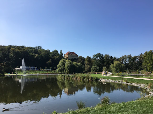 Stromovka's lake and fountain with the Governor's summer house on the hill