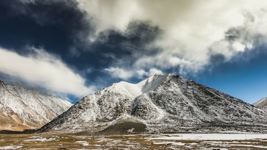 snow covered mountain under blue sky during daytime in Leh India