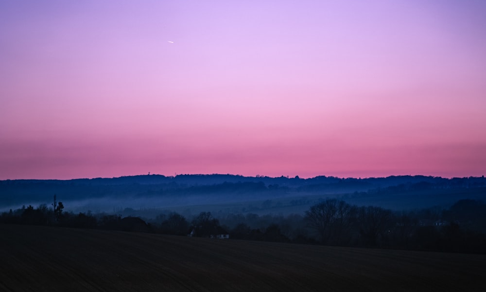 green grass field during sunset