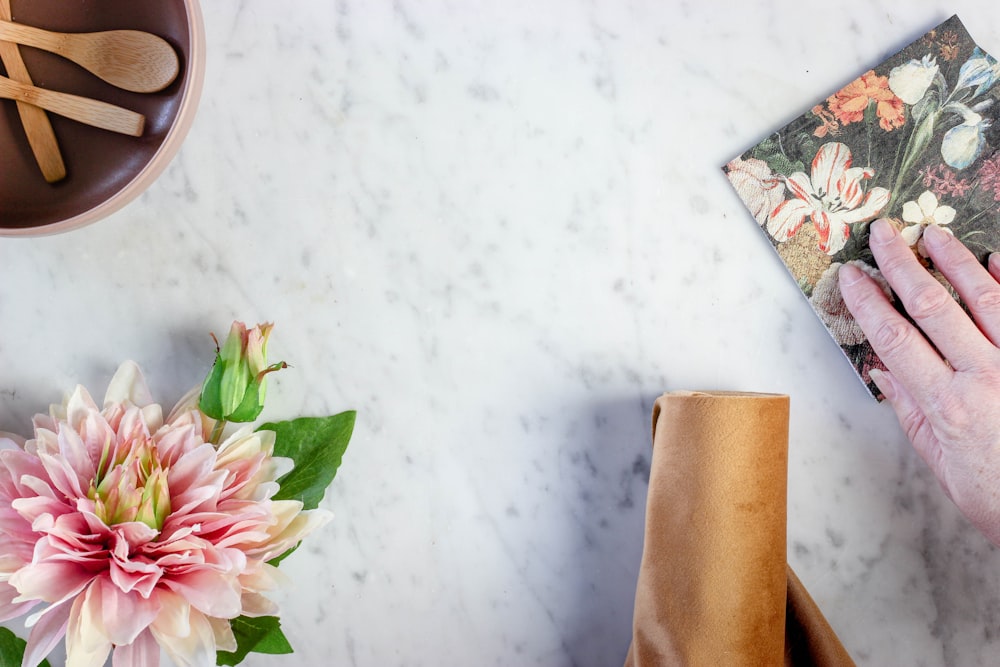 pink and white flower on white textile