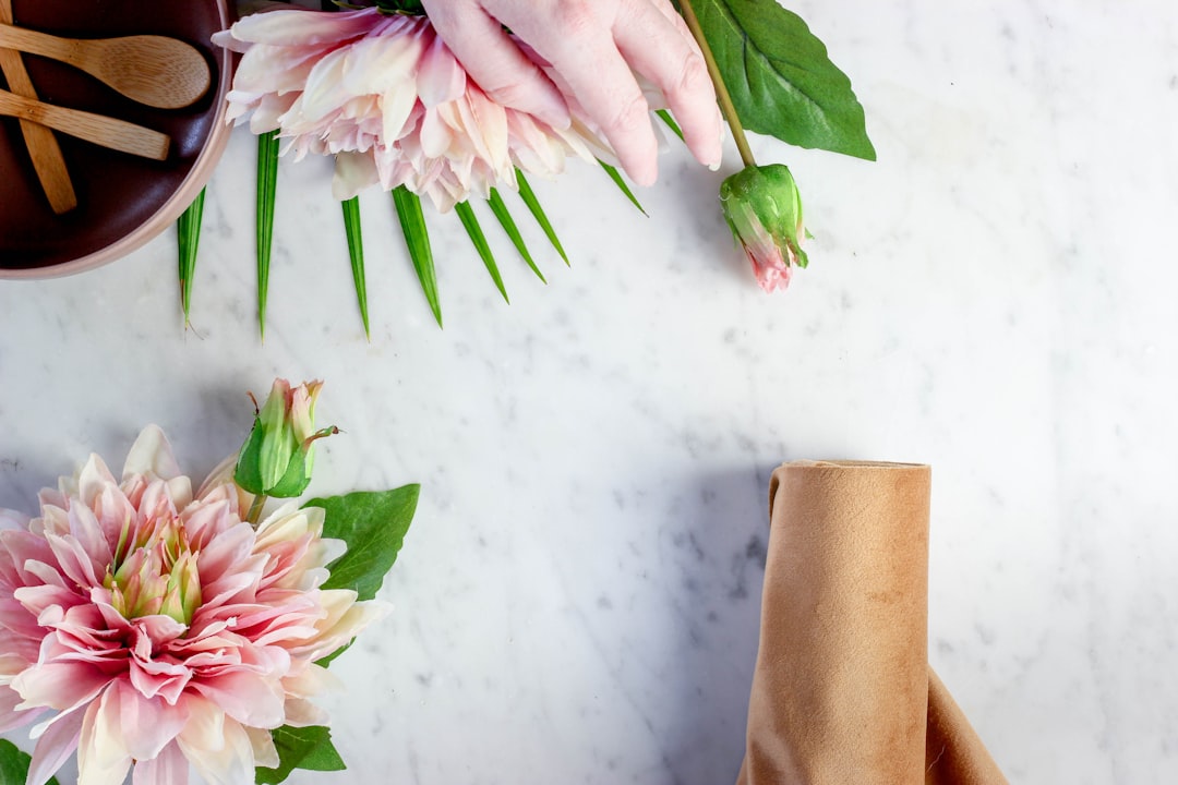 pink and white flower on white textile