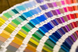 A fan deck of colorful paper swatches arranged in a spectrum on a surface