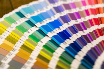 A fan deck of colorful paper swatches arranged in a spectrum on a surface