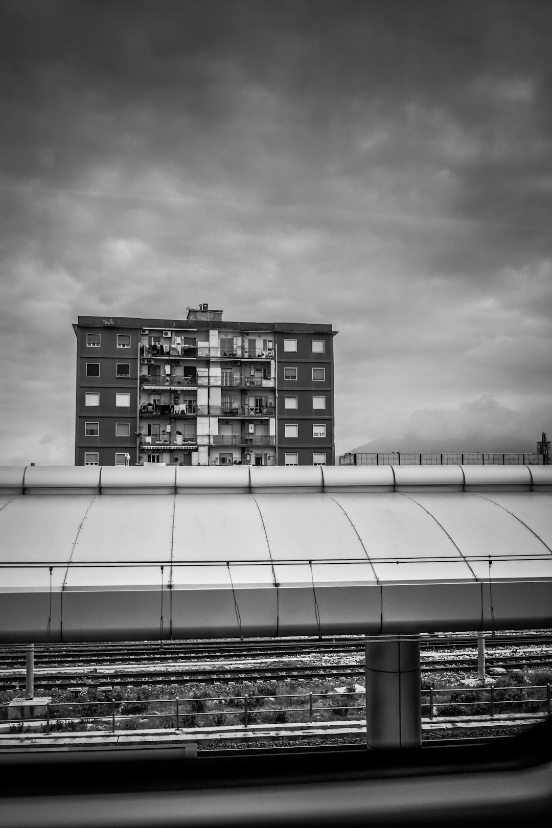 grayscale photo of building under cloudy sky