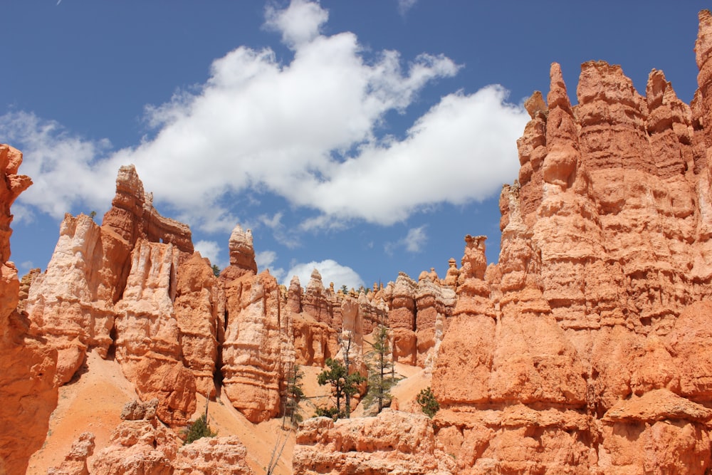 brown rock formation under blue sky and white clouds during daytime