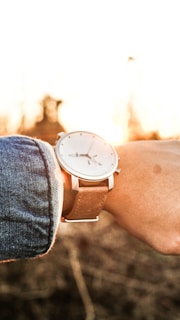 Customer wearing a deluxe reps watch, smiling and checking the time in natural light.