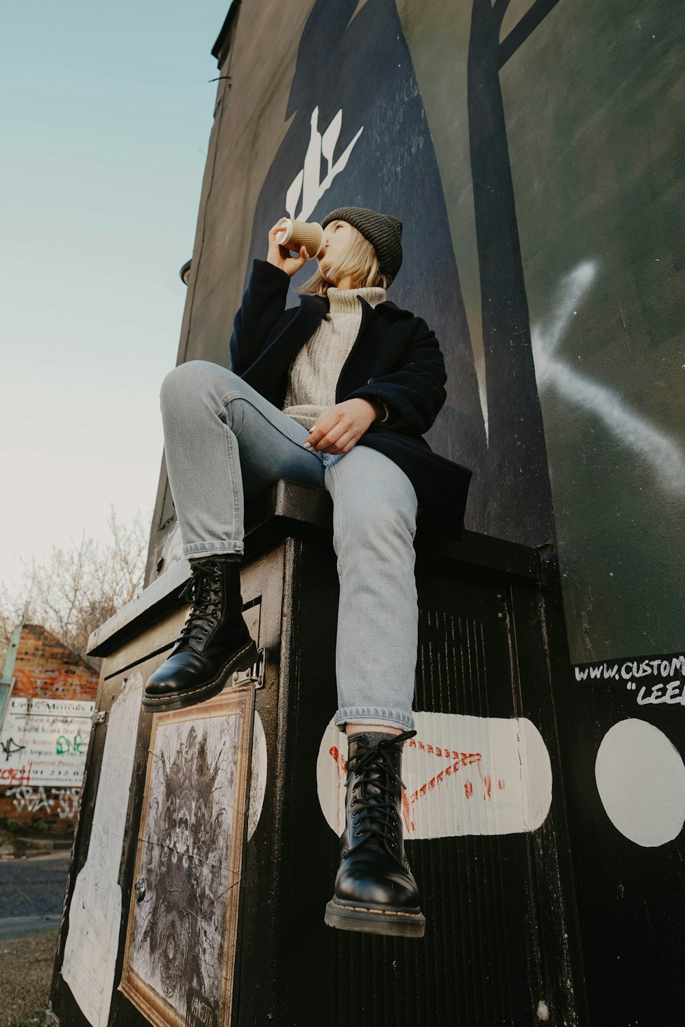 a person sitting on a wall with a stuffed animal