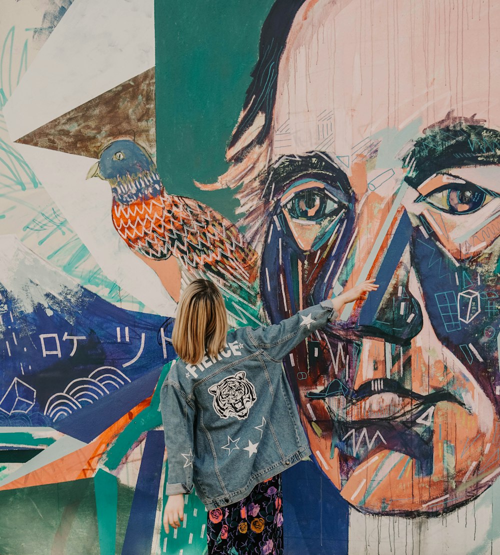 woman in black and white long sleeve shirt standing beside wall with graffiti