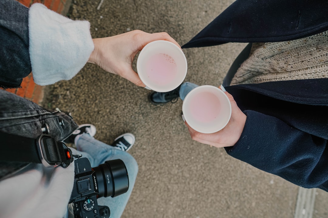 person holding white plastic cup