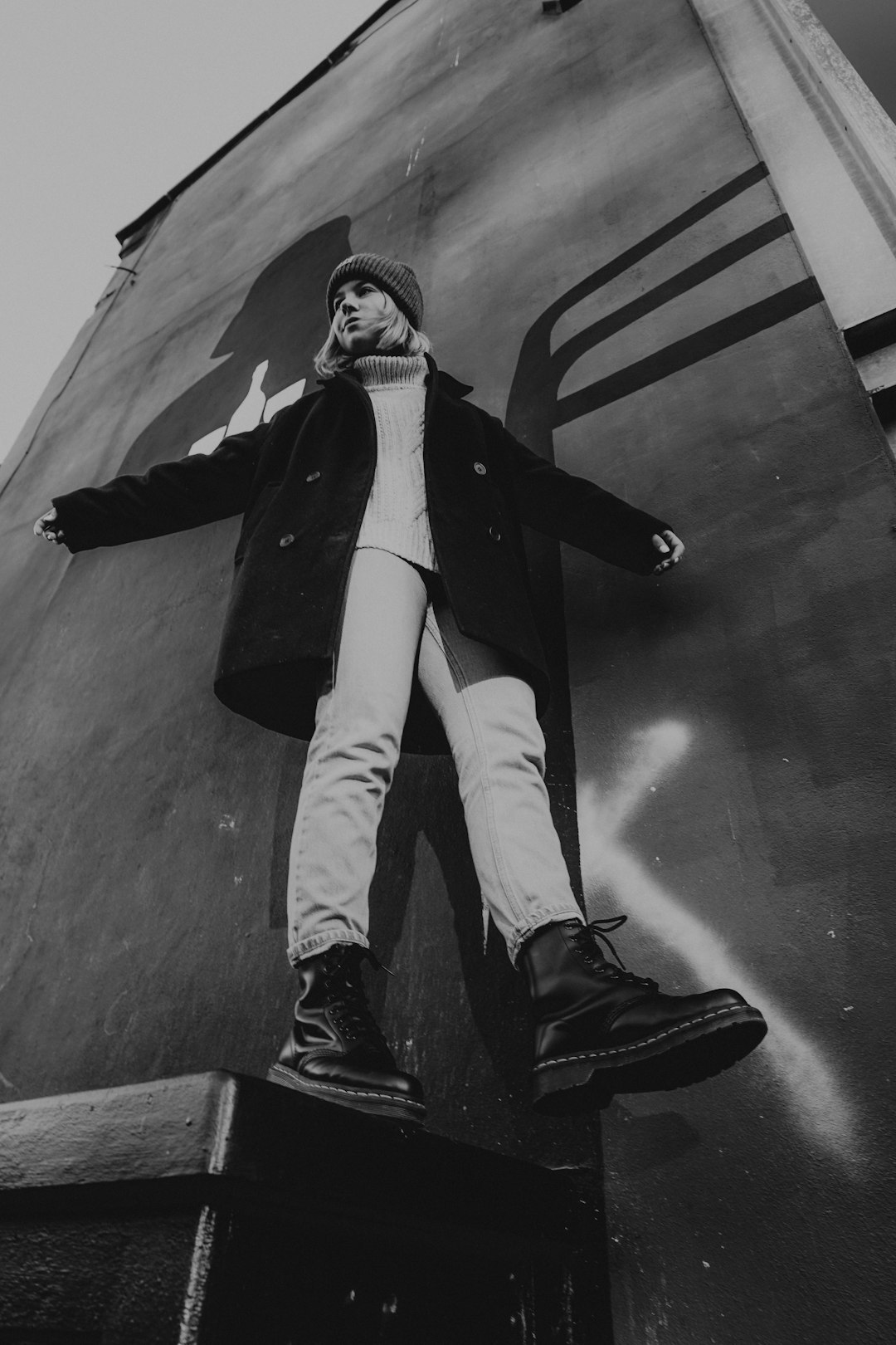 man in black coat and white pants wearing black leather boots