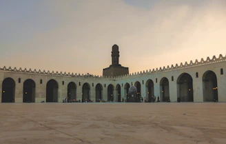 A serene courtyard of Jamia Ul Uloom Multan with students engaged in study under shaded arches.