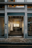 A modern commercial building entrance with automatic glass doors.