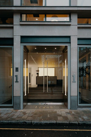 A bright, modern office entrance featuring sleek smart doors in action during daytime.