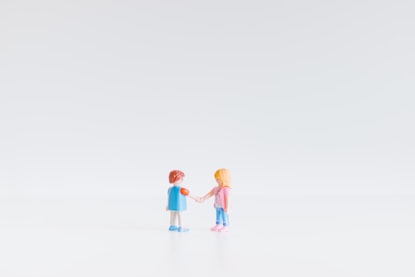 Photo of two toy figures shaking hands, by Paweł Czerwiński